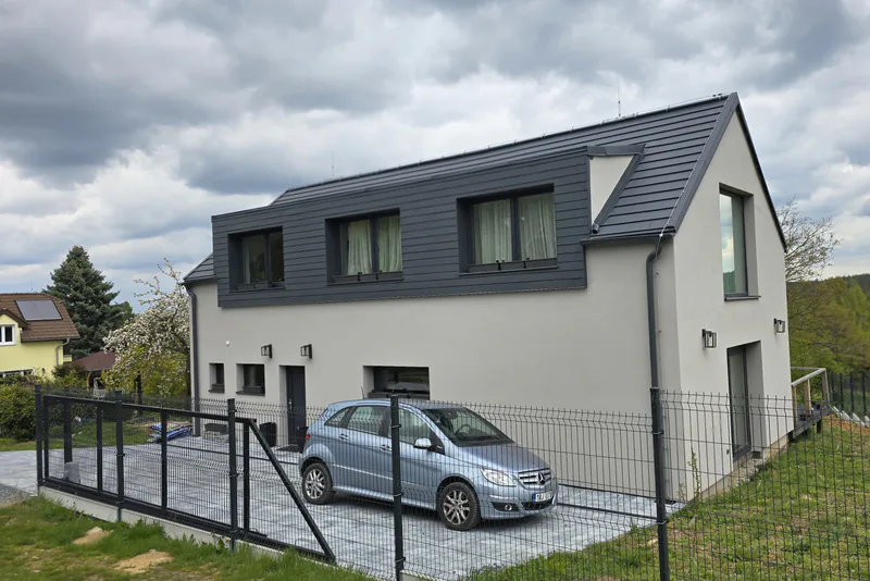Dokončovaný rodinný dům v českém prostředí se zpevněnou příjezdovou plochou