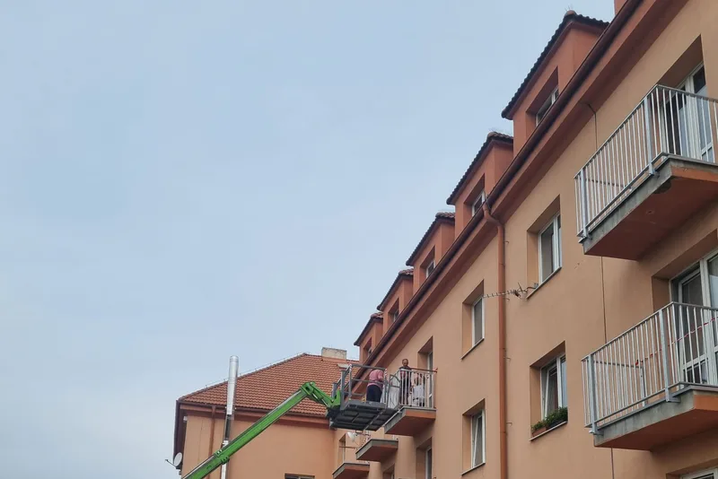 Práce na fasádě bytového domu z teleskopického manipulátoru